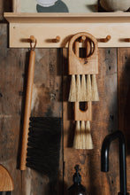 Load image into Gallery viewer, SETTLE | Slow Made Goods - an oak hand brush with natural bristles hanging neatly from a set of pegs with other practical household wares at Settle.