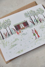 Load image into Gallery viewer, Shop at Settle | Harriet Watson A Walk in the Woods - charming hand illustrated colour greetings card of two guests enjoying a walk in Settle's wooded park, with Carriage No. 2 nestled in the background, set against a pale timber surface.