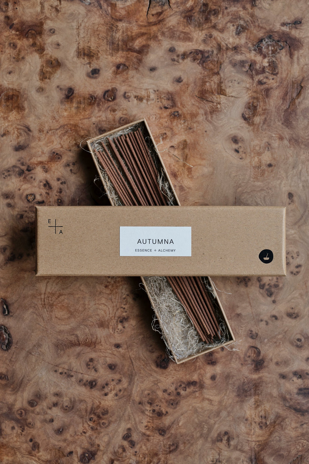 Natural cardboard packet of Autumna incense sticks by Essence + Alchemy, the box lid is open and laid across the box of sticks, which is lying on a natural wooden surface | Settle Norfolk  