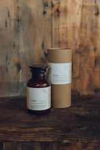 Load image into Gallery viewer, Glass apothecary bottle containing LUNA Bath Salts next to natural cardboard packaging, by Essence + Alchemy, at Settle Norfolk, UK | Copyright Settle Norfolk, UK