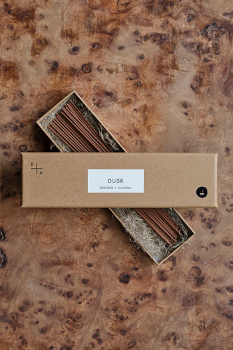 Open natural cardboard packet of 'Dusk' incense sticks by Essence + Alchemy on a natural wooden surface | Settle Norfolk 