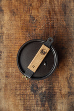 Load image into Gallery viewer, Shop at Settle | Netherton Foundry - cast iron glamping pot and lid in charcoal grey, with its wooden handle removed and lying across its lid next to one of its brass bolt fixings.