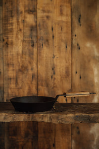 Shop with Settle | Netherton Foundry - profile of a hand-spun cast iron glamping pan with wooden handle.
