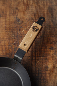 Shop with Settle | Netherton Foundry - overview close-up on wooden handle of a hand-spun cast iron glamping pan.