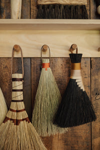 SETTLE | Wild Crafted Home Handmade Hand Brush - a selection of handmade brushes hanging on a row of pegs in Settle Shop at Settle.