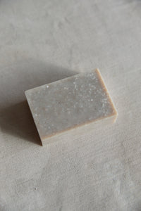 SETTLE | The Chemist's Daughter - an example of a bar of natural handmade soap to show the kind of soap bar which this bag has been designed to hold, on a pale grey marble surface at Settle. This soap bar is not included in the purchase of a soap bag.