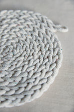 Load image into Gallery viewer, Shop at Settle The Chemists Daughter - close-up of a lovely, circle woven trivet handmade from 100% recycled pale cotton, set against a pale background  