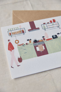 Shop at Settle | Harriet Watson Morning Coffee - charming hand illustrated colour greetings card showing the well-appointed kitchen in Settle's Lakeside Cabin, set on a pale timber background.    