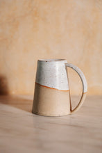 Load image into Gallery viewer, SETTLE | Every Story Ceramics Cosy Mug - profile of a sturdy handmade ceramic mug made in pale speckled clay with unique markings. Its base is broader than its rim, making it sturdy, and the elegant long handle curves from the top rim to the base making this mug hard to knock over. Pictured on a grey marble surface with a pale background at Settle. 