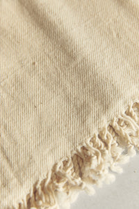 SETTLE | Pico Goods Bath Towel - close-up of handwoven organic cotton bath towel in a natural off-white with tasselled edging at Settle.