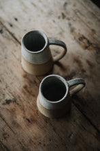 Load image into Gallery viewer, SETTLE | Every Story Ceramics Cosy Mug - top view of two handmade ceramic mugs handmade in pale speckled clay. With their broad bases and long curved handles these mugs are sturdy and practical, seen here on antique timbers at Settle.